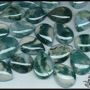 May include: A collection of moss agate cabochons in various shades of green and white. The cabochons are teardrop shaped and have a smooth, polished finish.