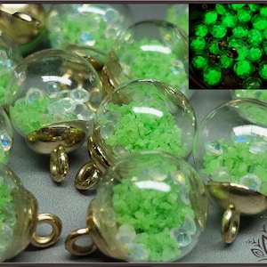 May include: A group of small glass ornaments filled with green glitter and iridescent glitter. The ornaments have gold metal caps and loops for hanging.