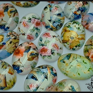 May include: A collection of oval glass cabochons featuring printed designs of colourful birds, blooming flowers, and wooden birdhouses. Each piece has a smooth, domed surface with a glossy finish, displaying various floral and avian patterns.