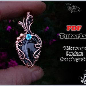Könnte beinhalten: Ein drahtgewickelter Anhänger mit einem tropfenförmigen schwarzen Stein, der mit einem kleinen, hellblauen runden Edelstein verziert ist. Der Kupferdraht ist kunstvoll um den Stein gewickelt. Text: PDF Tutorial Wire wrap Pendant Ace of spades.
