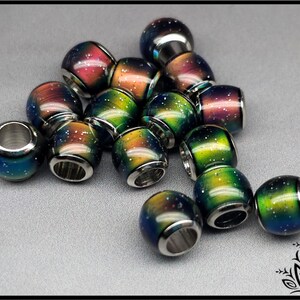May include: A collection of round beads featuring a gradient color transition from blue to green to orange and red. Each bead has a metallic silver core and a smooth surface speckled with tiny white dots resembling a starry night sky pattern.