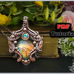 Peut inclure: Un pendentif en fil de cuivre enroulé avec une pierre irisée colorée et un cristal transparent. Le pendentif est sur une chaîne et repose sur un livre. L'image comprend le texte "Tutoriel PDF".