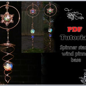 Op de afbeelding: Een windmolen van koperdraad met een stervormige bovenkant en een spiraalvormige basis. De ster heeft een iriserend glazen centrum en de basis heeft een kleurrijke glazen bol. De windmolen hangt aan een haak en bevindt zich voor een groene achtergrond.