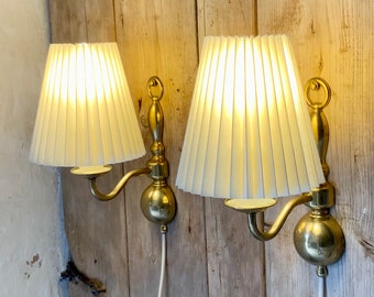 Pair of Darø brass wall lamps with new pleated, cream linen lampshades. Danish lighting.