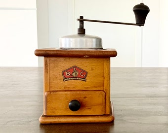 Vintage German “B.C. wooden Geschmiedetes Mahlwerk” coffee grinder / mill with metal handle and grinding mechanism.