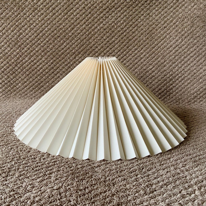 Clip on shade: Cream linen, pleated lampshade, available in two styles, for table lamps/wall lights. Danish designed. Eastern