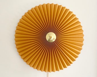 Danish designed, rosette wall light, with ochre yellow linen mix, pleated lampshade and brass centre finial.