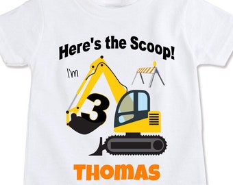 May include: White t-shirt with a construction theme. The shirt features a yellow excavator with the number 3, the name "THOMAS", and the phrase "Here's the Scoop!" in black and orange text. A construction barrier is also included.