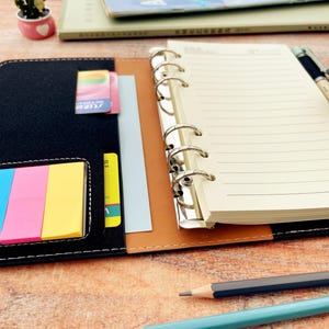 Op de afbeelding: Een witte keramische mok met een zwart handvat en de tekst "But First, Coffee" in handschriftstijl. De mok staat op een wit oppervlak. De mok is 10 cm hoog.