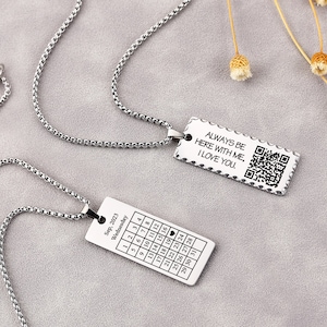 Può includere: Due collane d'argento con ciondoli rettangolari abbinati. Un ciondolo presenta un design di calendario con la data "Sep, 2023" e la parola "Wednesday". L'altro ciondolo ha il testo "ALWAYS BE HERE WITH ME, I LOVE YOU." e un codice QR.