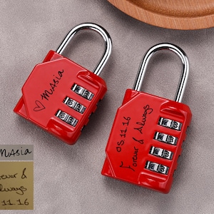 Op de afbeelding: Twee rode combinatiesloten met zilveren beugels. Op één hangslot staat de naam "Masia" en een hartsymbool. Op het andere hangslot staan de woorden "Forever & Always" en de datum "05.11.16".