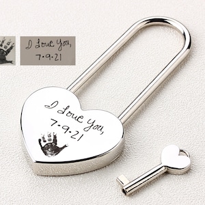 May include: Silver heart-shaped padlock with a key. The padlock has an inscription that reads "I love you, 7-9-21" and a handprint.