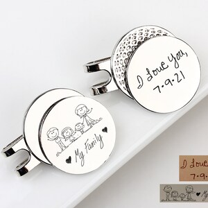 May include: Silver cufflinks with engraved designs. One cufflink features a golf ball design with the inscription "I Love You, 7.9.21." The other cufflink has a family stick figure design with the words "My Family."