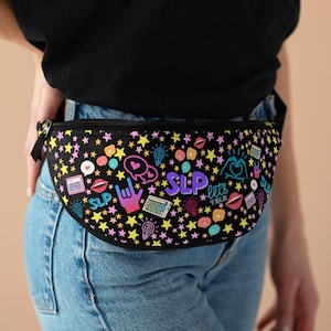May include: A black fanny pack with a colorful design featuring stars, hearts, light bulbs, and the text "SLP lets talk".