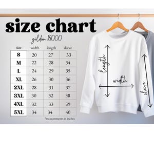 May include: A white Gildan 18000 sweatshirt hangs on a wooden hanger, with a size chart to the left. The chart displays measurements in inches for sizes S through 5XL, including width, length, and sleeve dimensions. The text "size chart" is at the top.