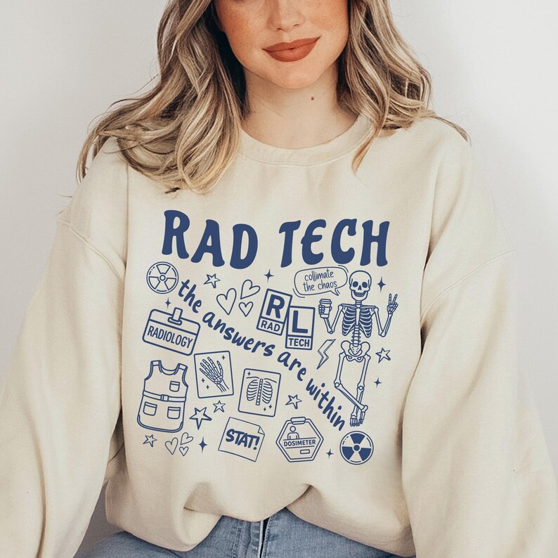 May include: Cream-colored sweatshirt with the words "RAD TECH" in navy blue, along with various medical-themed graphics. The design includes a skeleton, radiology symbols, and the phrase "the answers are within."