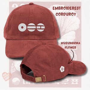 Puede incluir: Gorra de béisbol de pana color óxido con diseño bordado en blanco. La gorra presenta el texto "EMBROIDERED! CORDUROY" y un diseño floral blanco. La gorra también tiene el texto "MUGUNGHWA FLOWER".