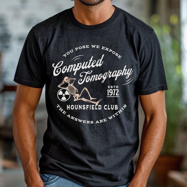 Puede incluir: Una camiseta negra con un dise&ntilde;o gr&aacute;fico blanco que presenta un esqueleto sentado en una tomograf&iacute;a computarizada. El texto dice "You Pose We Expose Computed Tomography Estd 1972 The Hounsfield Club The Answers Are Within."