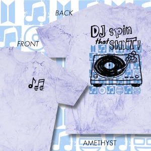 May include: Amethyst-colored t-shirt with a marbled effect. The front features a small black musical note design. The back displays a turntable graphic with the text "DJ spin that SHIT!" in black. The shirt has a crew neck.