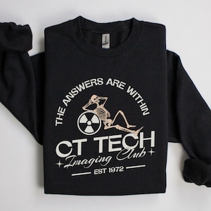 May include: Black sweatshirt with a white graphic of a skeleton sitting on a radiation symbol. The graphic says "The answers are within CT Tech Imaging Club - Est 1972".