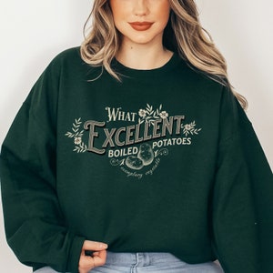 May include: A dark green sweatshirt with a white graphic print that says "What Excellent Boiled Potatoes, exemplary vegetable".