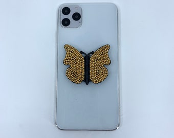 Black butterfly phone stand grip with gold rhinestones. Wings adjust to different levels & butterfly turns on base. Fits all phone models.