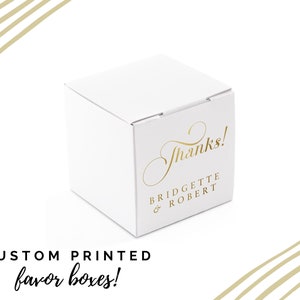 Könnte beinhalten: Weiße Geschenkbox mit goldener Aufschrift "Danke!" und den Namen "Bridgette & Robert".