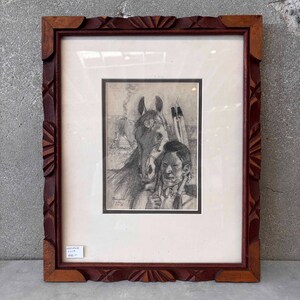 Puede incluir: Un boceto a lápiz enmarcado que presenta a un hombre nativo americano y un caballo con gafas. La obra de arte está ambientada sobre un fondo de un tipi y flechas. El marco es de madera marrón oscuro con detalles tallados.