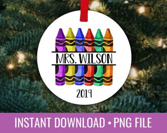 May include: A white round ornament with a design of six colorful crayons with the text "MRS. WILSON" and the year "2019" printed on it.