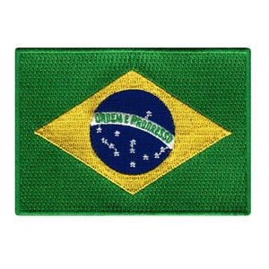 Puede incluir: Un parche bordado que representa la bandera de Brasil. La bandera es verde con un diamante amarillo en el centro, que contiene un círculo azul con estrellas blancas y las palabras "Ordem e Progresso" en blanco.