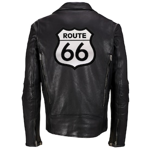 Puede incluir: Chaqueta de cuero negra con un parche blanco de la Ruta 66 en la espalda.