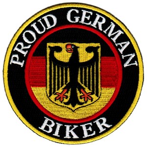 Könnte beinhalten: Ein gestickter Aufnäher in Schwarz und Gelb mit dem Text "Proud German Biker" in weißen Buchstaben um einen schwarzen Adler mit rotem Schnabel und Krallen auf einem gelben und roten deutschen Flaggenhintergrund.