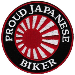 May include: A black and white embroidered patch with a red rising sun design in the center. The text "Proud Japanese Biker" is written around the sun design.