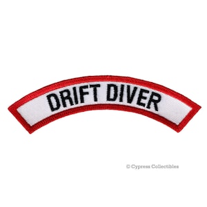 Puede incluir: Parche blanco con ribete rojo y texto negro que dice "DRIFT DIVER".