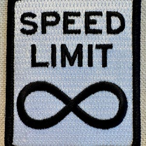 May include: White embroidered patch with black stitching. The patch reads "SPEED LIMIT" with an infinity symbol below the text.