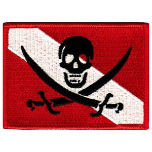 May include: A red and white scuba diving flag with a black skull and crossbones. The skull has one eye and a toothy grin.