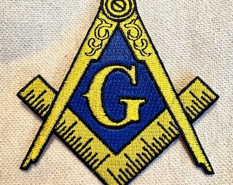 May include: A yellow and blue embroidered patch with a Masonic symbol, a square and compass with a 'G' in the center.