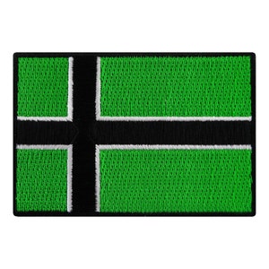 Puede incluir: Parche bordado verde y negro con un contorno blanco. El parche presenta un fondo verde con una cruz negra.