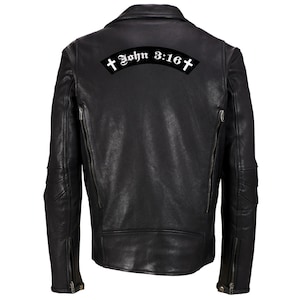 Op de afbeelding: Zwart leren motorjack met een wit geborduurd patch op de rug met de tekst "John 3:16" met een kruis aan elke kant van de tekst.
