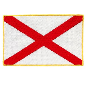 May include: A red cross on a white background with a yellow border. This is an embroidered patch of the Alabama state flag.