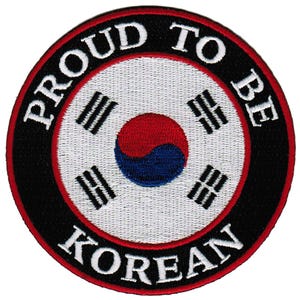Puede incluir: Un parche bordado en blanco y negro con la bandera de Corea del Sur en el centro. El texto "Proud to be Korean" está escrito alrededor de la bandera en un círculo blanco.