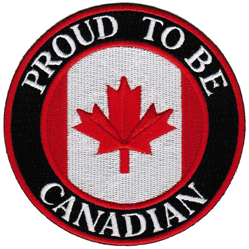 May include: A black and white circular patch with the words "Proud to be Canadian" around the edge. The center of the patch features a red maple leaf on a white background with a red stripe on the left and right sides.