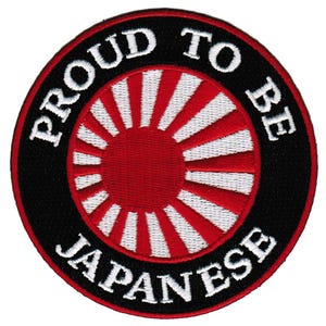 May include: A black and white embroidered patch with a red and white rising sun design in the center. The text "Proud to be Japanese" is written around the sun design.