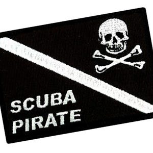 Può includere: Toppa ricamata in bianco e nero con un teschio e ossa incrociate e il testo "SCUBA PIRATE".