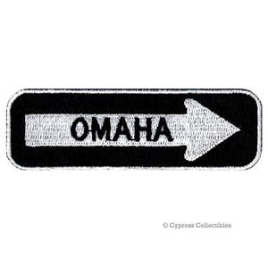 May include: Black and white embroidered patch with a white arrow pointing to the right and the word "OMAHA" in white letters.