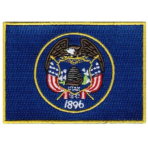 Puede incluir: Parche bordado de la bandera del estado de Utah. La bandera es azul con un círculo dorado en el centro. El círculo contiene un águila dorada con un escudo rojo, blanco y azul. El escudo tiene una colmena y las palabras "Utah 1847" y "1896".