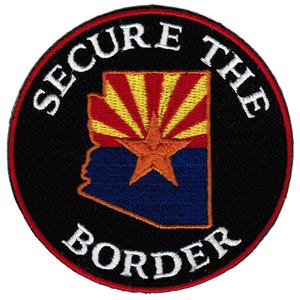 May include: A black and red circular patch with white text that reads "SECURE THE BORDER" around the outline of the state of Arizona with the Arizona state flag design inside.