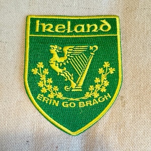 May include: Green and yellow embroidered patch with the word "Ireland" at the top, a harp with a golden lion holding it, and the words "Erin Go Bragh" at the bottom.