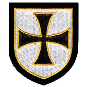 May include: A black and white embroidered patch with a black cross on a white background. The cross is outlined in yellow and the patch is shaped like a shield.
