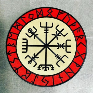 May include: Red and white embroidered patch with a black compass design and runes around the edge. The compass has eight points and is surrounded by a circle of runes.
